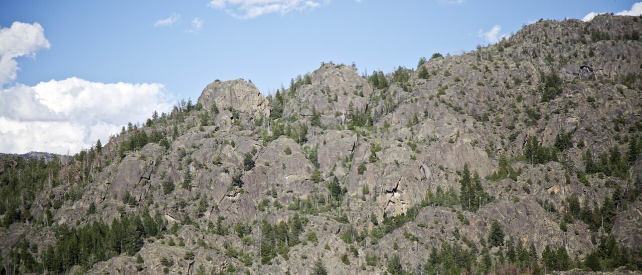 Granite dome formations at Boulder Lake Domes above forest and cabins near Boulder, Wyoming