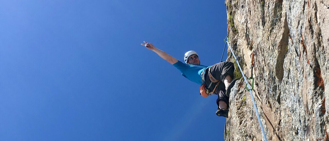 Climber on sport rock under blue sky at Rock Springs Buttress — Sky Lounge area