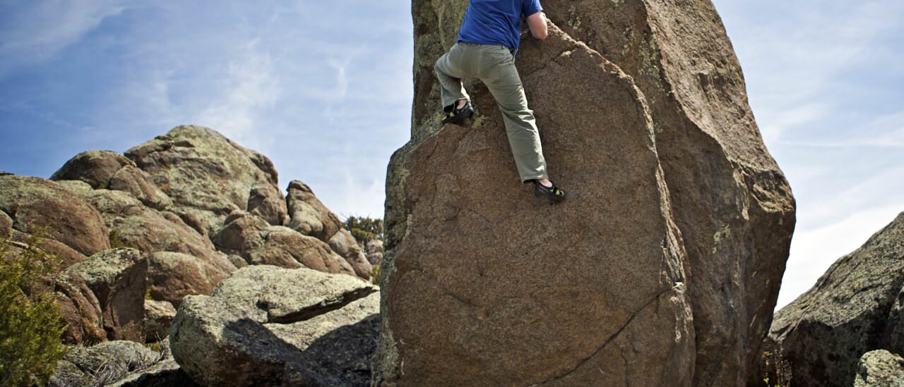 Boulderer on a large granite boulder at The Galaxy near Boulder, Wyoming